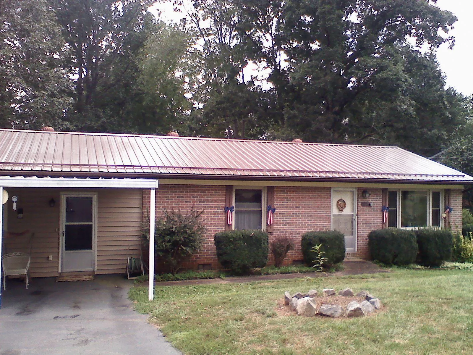 Bronze metal roof and carport on a brick ranch home — Roof Repair work by our crew in Bailey Island